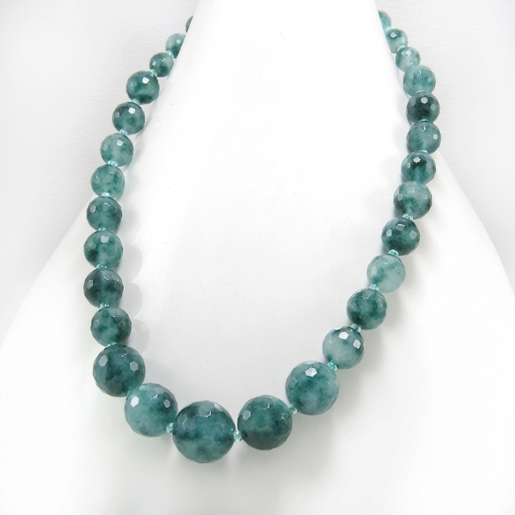 Graduated faceted dark green candy jade bead necklace on a white display.